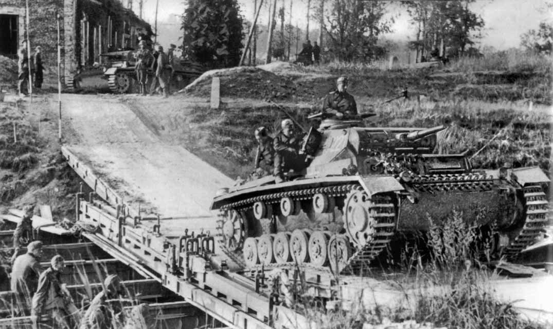 Engineers and a tank on a military bridge. Bridging the Meuse under fire was the decisive act of the battle.
