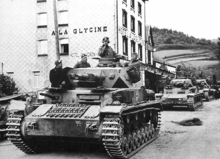 A Panzer IV and the column behind it halted in a French town during the drive west.